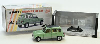 une petite voiture verte en plastique devant une boîte