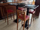 tables and chairs in a restaurant with a bar in the background