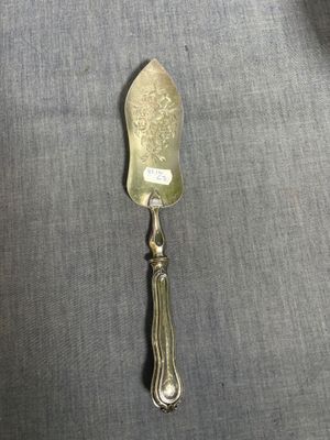 une cuillère en argent avec un manche en argent posée sur un linge gris