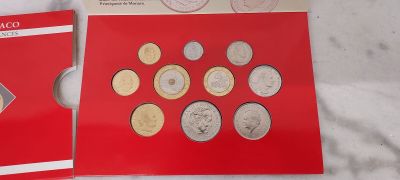 deux livrets rouges ornés de pièces d'argent, posés sur une surface blanche