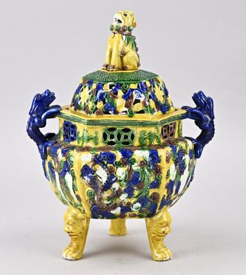 une image représentant un vase jaune et bleu surmonté d'un chien