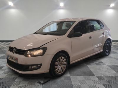la volkswagen polo blanche est garée dans une pièce au sol à carreaux