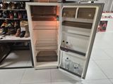an open refrigerator in a store with shoes on the shelves