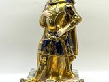 une figurine dorée et bleue représentant un homme en armure