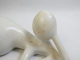 a white sculpture of a person laying down on a white surface
