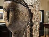 a sculpture of a woman ' s head on display in a museum