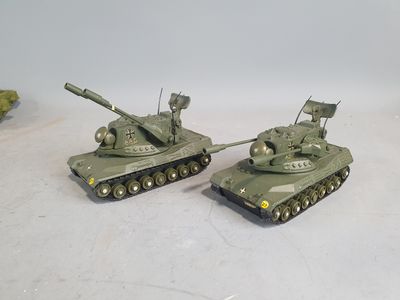 two toy tanks sitting next to each other on a table