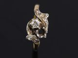 a close up of a gold and diamond ring on a black surface
