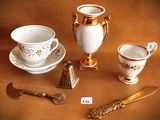 a gold and white tea set on a brown table