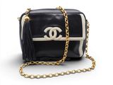 un sac Chanel noir et blanc avec une chaîne dorée