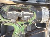 a green drill that is sitting in a box