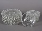paire de bougeoirs en verre transparent avec des bords ornés de perles sur fond gris