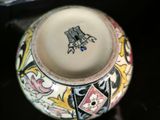 a close up of a vase with a bird on it