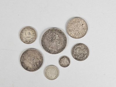 an assortment of silver and silver coins on a white surface
