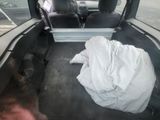 a dog laying in the back of a car with a blanket on it