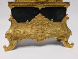 a gold clock sitting on top of a black marble table
