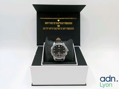 l'image d'une montre dans une boîte sur une surface blanche