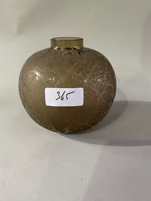 un vase marron sur lequel est collé un autocollant, posé sur une table