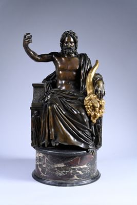 an antique bronze statue of a man sitting on top of a chair