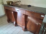 a kitchen with a marble counter top and a wooden cabinet