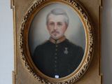 une vieille photo d'un homme en uniforme militaire dans un cadre doré