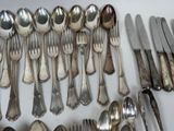 a lot of silver spoons and spoons on the table