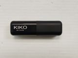 a close up of a black pill on a white surface