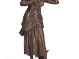 bronze statue of a woman with a hat on her head