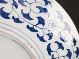 a blue and white plate with a flower design on it
