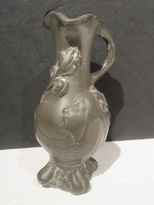 un vase en argent posé sur une table blanche