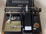 an old typewriter sitting on a table with a cell phone on it