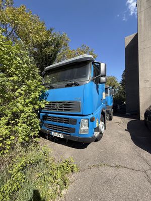 un camion bleu garé à côté d'un immeuble