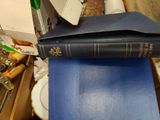 a blue book sitting on top of a stack of books