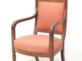 an old wooden chair with an orange upholstered seat