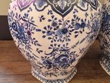 pair of blue and white vases sitting on top of a wooden table