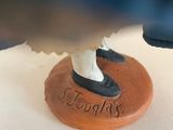 a small figurine of a woman with a shoe on top of a cake