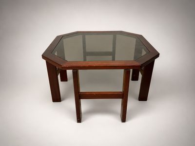 an octagonal glass table with wooden legs and a glass top