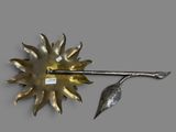 a metal object with a leaf on it on a gray surface