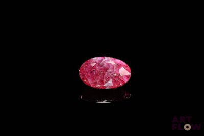 a close up of a pink diamond on a black surface