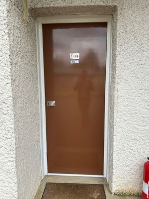 une borne d'incendie rouge devant une porte marron