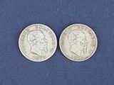 deux pièces d'argent posées sur un tissu bleu