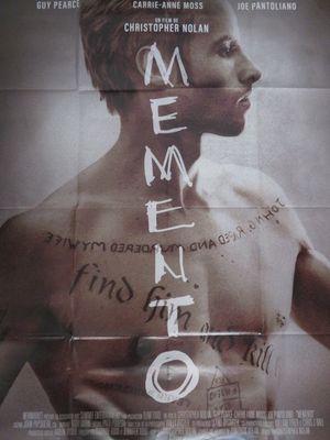 affiche représentant un homme avec des tatouages sur la poitrine et le mot « mementoe » inscrit sur sa poitrine