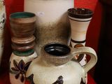 many different vases on a red table with a red wall in the background