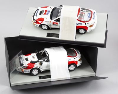 une voiture blanche et rouge dans une boîte avec un rouleau de papier toilette