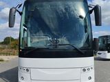 a white bus that is parked in a parking lot