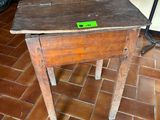 a small wooden table with a green label on it