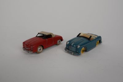 two toy cars sitting next to each other on a white surface