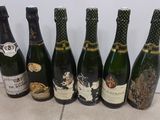 six bottles of wine are lined up on a tile floor