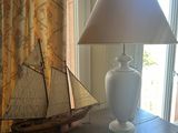 a table with a lamp and a sailboat on it