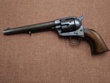 an old revolver with a wooden handle on a brown surface